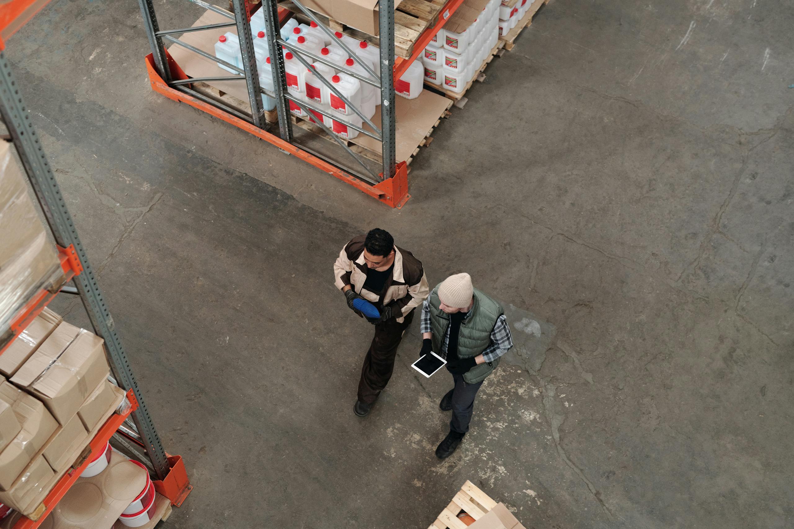 Two warehouse workers review inventory on a tablet